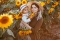 Young beautiful mother and her little cute son walk in a field with sunflowers, have fun, run and have fun together Royalty Free Stock Photo