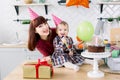 Young beautiful mother and her little daughter are celebrating a birthday. cake with candles. happy birthday baby Royalty Free Stock Photo