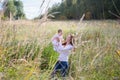 Young beautiful mother holding a baby girl wearing a pink dress in a meadow Royalty Free Stock Photo