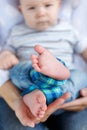 Young beautiful mother holding baby son on her lap, sitting on a bed Royalty Free Stock Photo