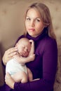 Young beautiful mother holding sleeping newborn baby on hands in
