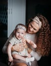 Young beautiful mother holds her baby daughter in her arms and looks at her Royalty Free Stock Photo