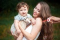 Young beautiful mother hugging her little toddler son against green grass. Happy woman with her baby boy on a summer Royalty Free Stock Photo