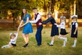 Young beautiful mother leads five children to school. Mother of many children. Large family. Happy together. Royalty Free Stock Photo