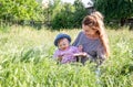 Young beautiful mother playing in the grass with her little baby daughter in panama Royalty Free Stock Photo