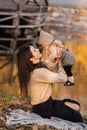 Young beautiful mother playing with her daughter on blanket near pond in autumn park on sunny day. mother`s day Royalty Free Stock Photo