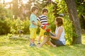 Young beautiful mother, sitting in a garden, little boys, her so Royalty Free Stock Photo