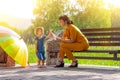 A young beautiful mother with a small daughter sit happy on a bench in the Park and blow soap bubbles Royalty Free Stock Photo