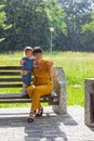 A young beautiful mother with a small daughter sit happy on a bench in the Park Royalty Free Stock Photo