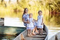 young beautiful mother spending time together with children in boat on lake at park. mothers day. womens day. Royalty Free Stock Photo