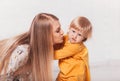 Young beautiful mother wants to kiss her little daughter. Mom and Her Child Having Fun together Royalty Free Stock Photo