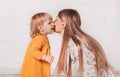 Young beautiful mother wants to kiss her little daughter. Mom and Her Child Having Fun together