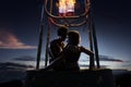 Young beautiful multiethnic couple kissing in the hot air balloon. night and sunrise around Royalty Free Stock Photo