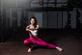 Young beautiful muscular attractive fit girl stretch her hand and body muscles after heavy hardcore cross workout training in the Royalty Free Stock Photo