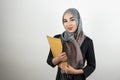 Young beautiful Muslim business woman wearing turban hijab headscarf holding folder with documents isolated white Royalty Free Stock Photo