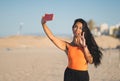 Young beautiful Muslim girl taking a selfie on the beach. Royalty Free Stock Photo