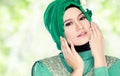 Young beautiful muslim woman with green costume wearing hijab
