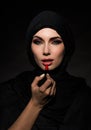 Muslim woman putting lipstick Royalty Free Stock Photo