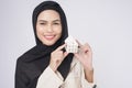 Young beautiful muslim woman in suit holding small model house over white background studio Royalty Free Stock Photo