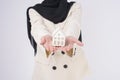 Young beautiful muslim woman in suit holding small model house over white background studio Royalty Free Stock Photo