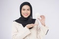 Young beautiful muslim woman in suit holding small model house over white background studio Royalty Free Stock Photo