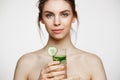 Young beautiful naked girl with perfect clean skin smiling looking at camera holding glass of water with cucumber slices Royalty Free Stock Photo