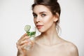 Young beautiful naked girl with perfect clean skin smiling looking at camera holding glass of water with cucumber slices Royalty Free Stock Photo
