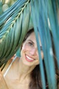 Young beautiful natural cheerful woman with healthy face and skin in exotic greenery. Closeup fresh face of attractive Royalty Free Stock Photo