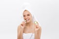 Young beautiful nude girl smiling hiding eyes behind cucumber slices over white background. Beauty skincare and Royalty Free Stock Photo