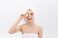 Young beautiful nude girl smiling hiding eyes behind cucumber slices over white background. Beauty skincare and Royalty Free Stock Photo