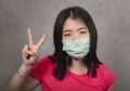 Young beautiful pacifist Asian woman in face mask angry and outraged protesting showing clean hands as symbol of peace standing