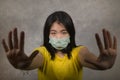Young beautiful pacifist Asian woman in face mask angry and outraged protesting showing clean hands as symbol of peace standing