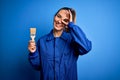 Young beautiful painter woman with blue eyes painting wearing uniform using paint brush with happy face smiling doing ok sign with Royalty Free Stock Photo