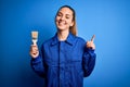 Young beautiful painter woman with blue eyes painting wearing uniform using paint brush surprised with an idea or question Royalty Free Stock Photo