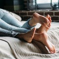 Young beautiful pair of lovers hug and kiss on the bed. Cropped image of lovers legs. People in jeans Royalty Free Stock Photo