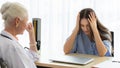 A young and beautiful patient talking to a doctor for history taking for a cure. She uses her hand to hold her head looks like she Royalty Free Stock Photo