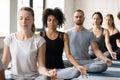 Young beautiful peaceful african american woman meditating with diverse people.