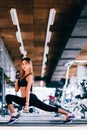 Young beautiful petite woman doing exercises with dumbbell in gym Royalty Free Stock Photo