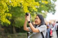 Young beautiful photographer with the professional camera taking photo beautiful autumn colourful maple leaf in Kyoto Japan Royalty Free Stock Photo