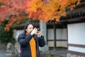 Young beautiful photographer with the professional camera taking photo beautiful autumn colourful maple leaf in Kyoto Japan Royalty Free Stock Photo