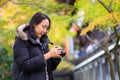 Young beautiful photographer with the professional camera taking photo beautiful autumn colourful maple leaf in Kyoto Japan Royalty Free Stock Photo