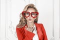Young Beautiful Playful Woman Looks Over Her Heart Shaped Red Glasses. Valentines Day, Love Or Theme Party Concept. Smokey Eyes