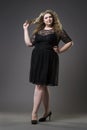 Young beautiful plus size model in black dres, xxl woman on gray studio background Royalty Free Stock Photo