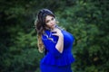 Young beautiful plus size model in blue dress outdoors, xxl woman on nature Royalty Free Stock Photo