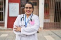 Young beautiful plus size woman doctor smiling confident standing with arms crossed gesture at hospital Royalty Free Stock Photo