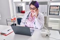 Young beautiful plus size woman doctor using laptop talking on telephone at clinic Royalty Free Stock Photo