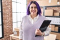 Young beautiful plus size woman ecommerce business worker holding clipboard at office Royalty Free Stock Photo