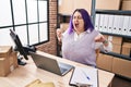 Young beautiful plus size woman ecommerce business worker tired stretching arms yawning at office Royalty Free Stock Photo