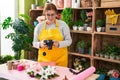 Young beautiful plus size woman florist make photo to bouquet of flowers gift at flower shop Royalty Free Stock Photo