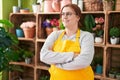 Young beautiful plus size woman florist smiling confident standing with arms crossed gesture at flower shop Royalty Free Stock Photo